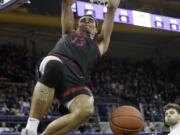 Stanford&#039;s Oscar da Silva hangs from the basket after dunking against Washington late in the second half of an NCAA college basketball game Thursday, Feb. 20, 2020, in Seattle. Stanford won 72-64.