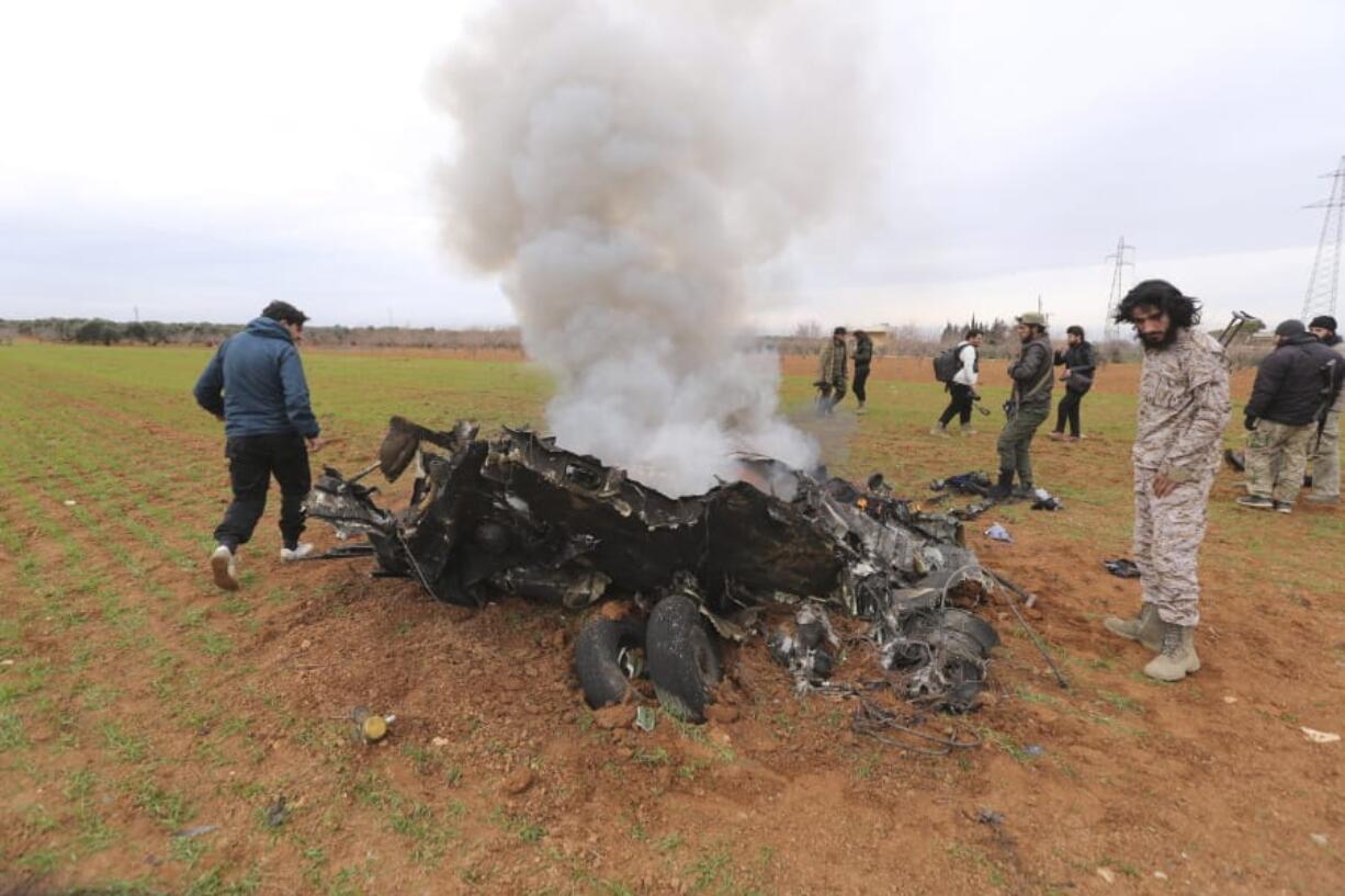 Rebel fighters look at a Syrian government helicopter that was shot down in Idlib province, Syria, Tuesday, Feb. 11, 2020. Syrian rebels shot down a government helicopter Tuesday in the country&#039;s northwest where Syrian troops are on the offensive in the last rebel stronghold.