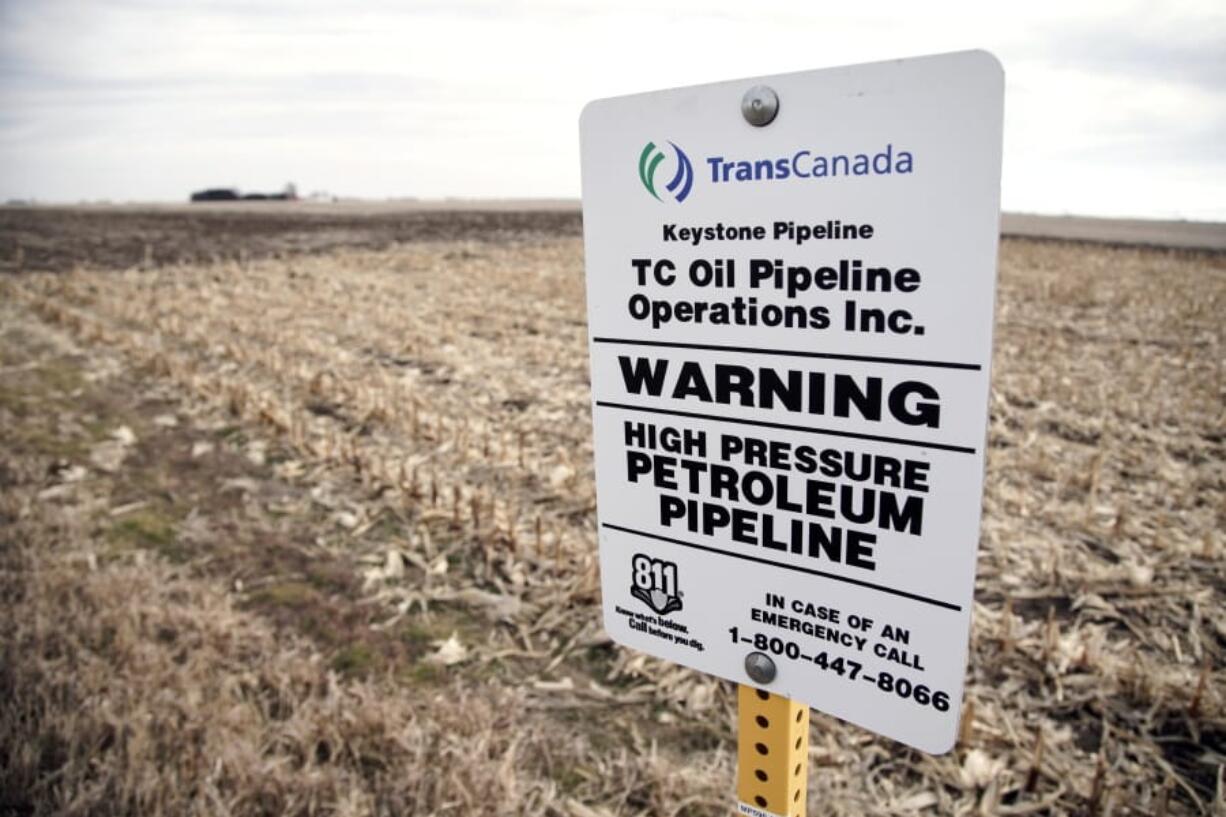 A sign identifies the existence of a buried oil pipeline under a corn field in rural Milford, Neb., Thursday, Jan. 9, 2020. In a dramatic rollback of environmental oversight, President Donald Trump took action Thursday to clear the way and speed up development of a wide range of commercial projects by cutting back federal review of their impact on the environment. The aim of the planned overhaul of the National Environmental Policy Act is to streamline environmental approvals for major construction efforts like highways, airports, pipelines and power plants.