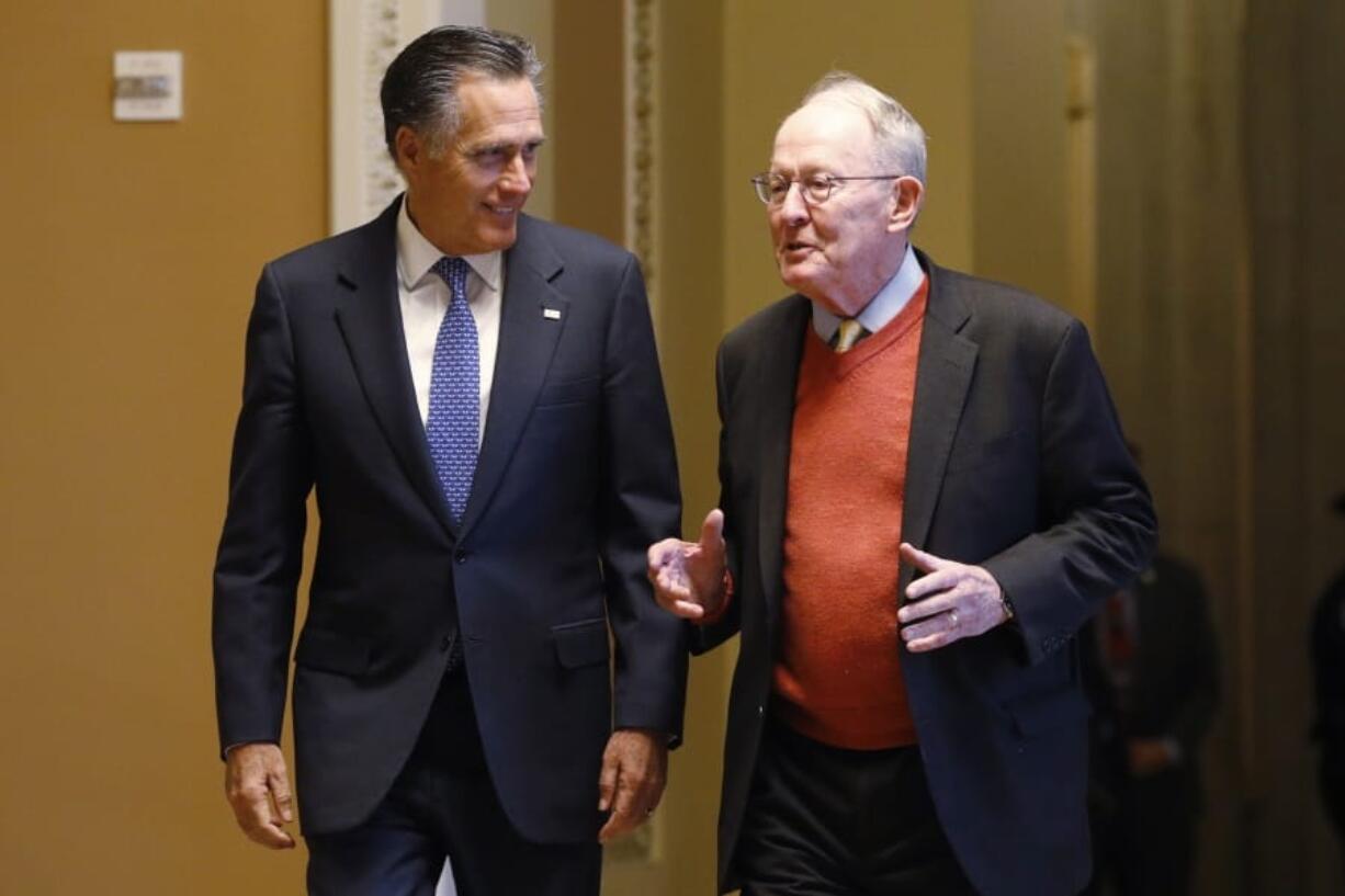 Sen. Mitt Romney, R-Utah, left, and Sen. Lamar Alexander, R-Tenn., return to the Senate chamber Friday after a meeting in the Majority Leaders office during a break in the impeachment trial of President Donald Trump at the U.S. Capitol in Washington.