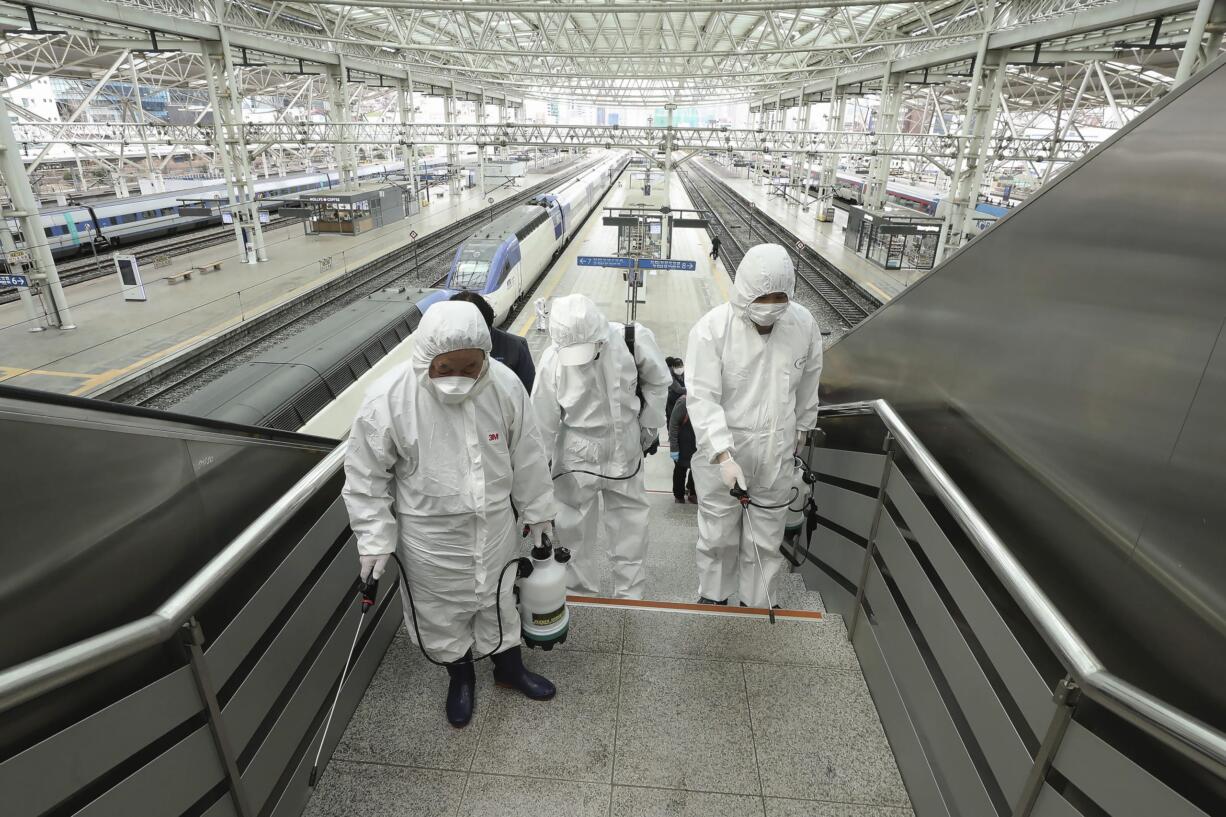 Workers wearing protective gears spray disinfectant as a precaution against the new coronavirus at Seoul Railway Station in Seoul, South Korea, Tuesday, Feb. 25, 2020. Clark County Public Health says it's ready should the virus COVID-19 show up here.