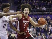 Washington State's CJ Elleby (2) drives against Washington's Jaden McDaniels (0) during the second half of an NCAA college basketball game Friday, Feb. 28, 2020, in Seattle. Washington State won 78-74.