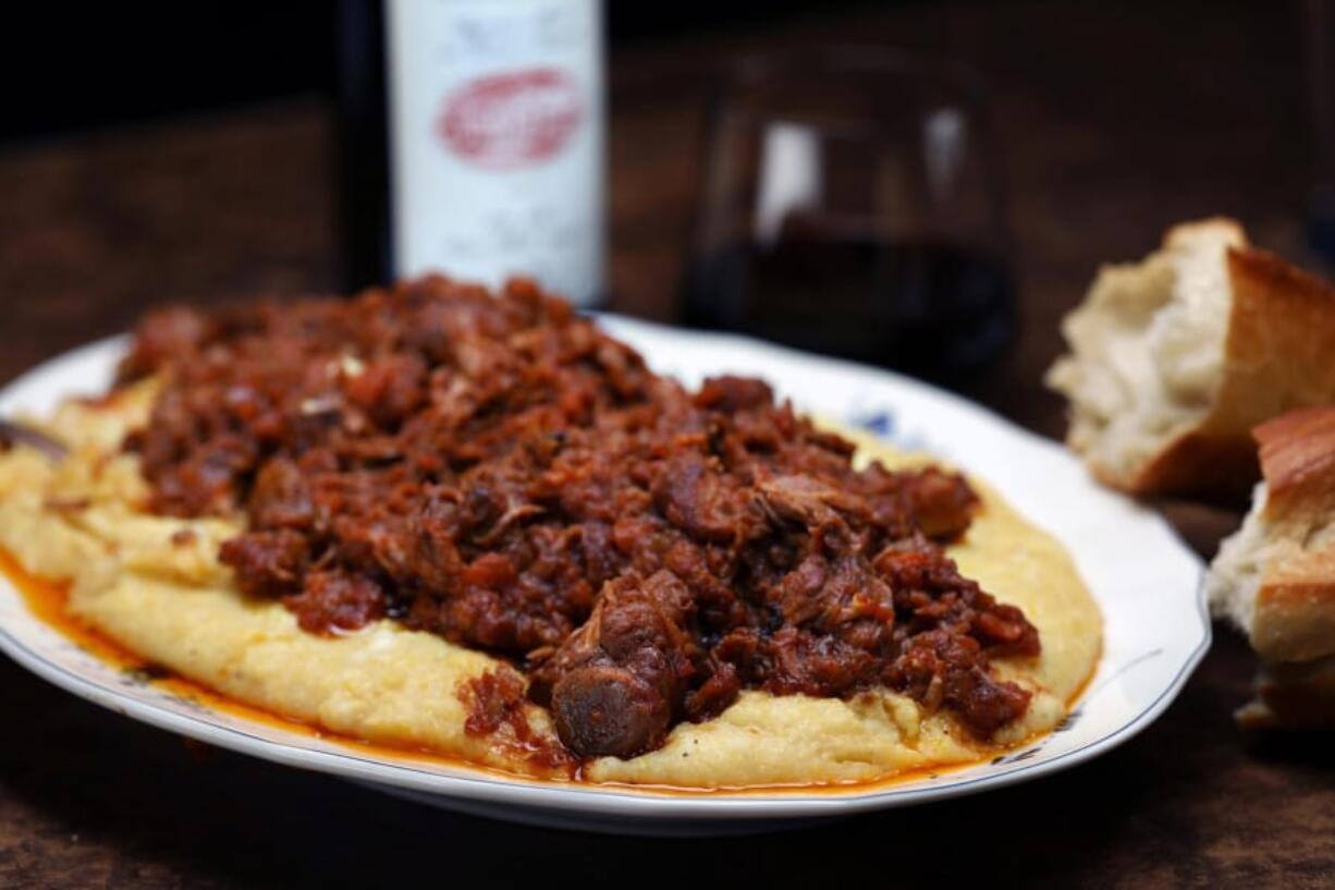 Baked polenta is topped with a pork ragu, spare ribs braised with aromatic vegetables, red wine and tomatoes. The dish calls for baking and slicing the finished polenta for serving. But you can also serve the ragu on a bed of the polenta, as shown here.