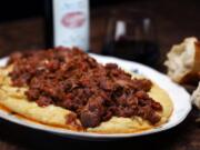 Baked polenta is topped with a pork ragu, spare ribs braised with aromatic vegetables, red wine and tomatoes. The dish calls for baking and slicing the finished polenta for serving. But you can also serve the ragu on a bed of the polenta, as shown here.