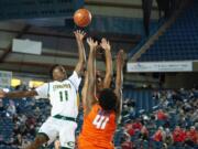 Evergreen's Mario Herring lifts a floater over a pair of Rainier Beach defenders in a 3A round of 12 game on Wednesday at the Tacoma Dome.