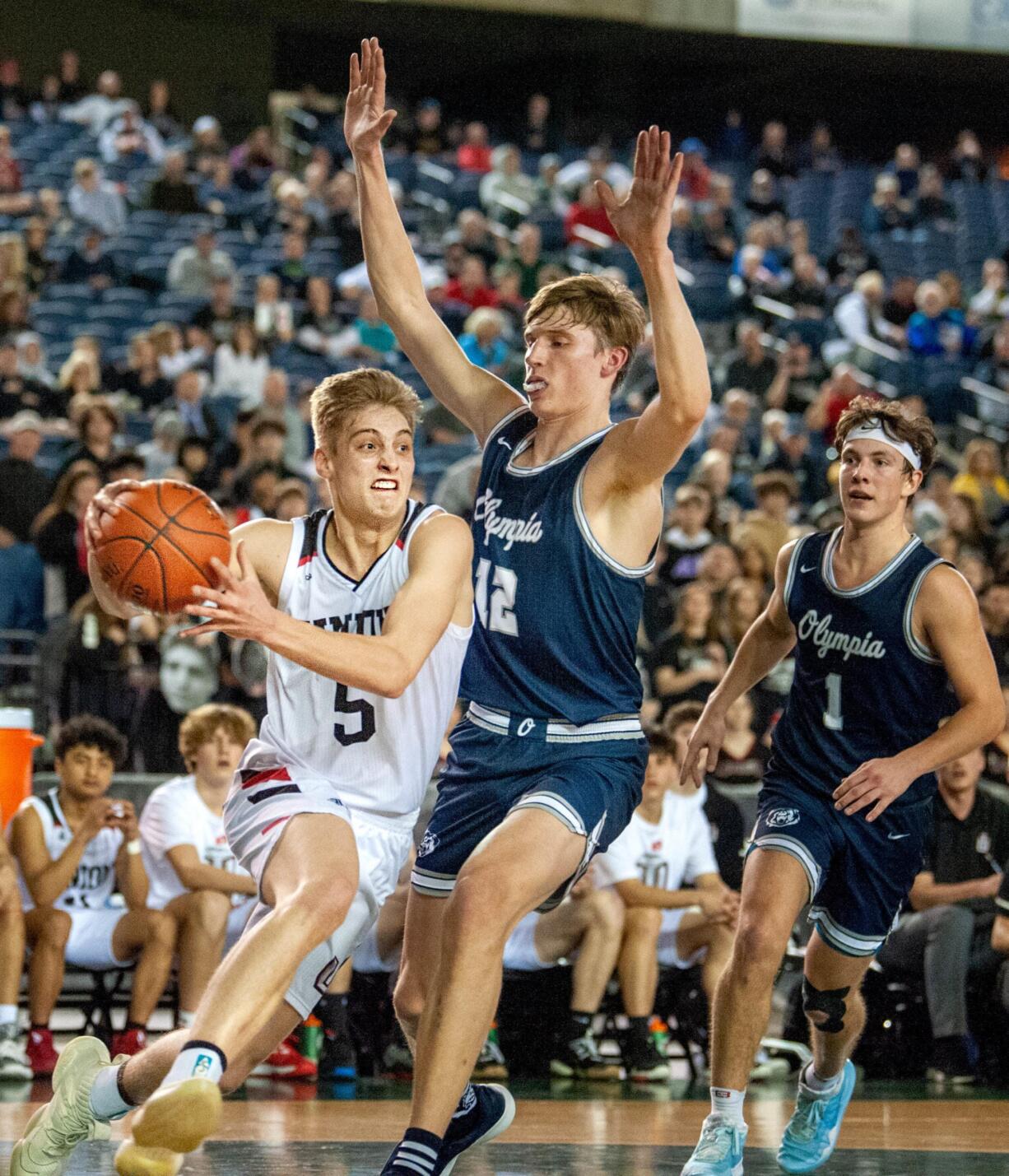 Union's Tanner Toolson drives past Olympia's Jackson Grant in a 4A State quarterfinal game on Thursday at the Tacoma Dome. Union won 69-56.