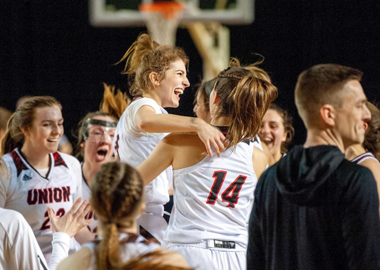 Union's Mason Oberg leaps into the air, helped by Kaneyl Carpenter (14) after the Titans' 56-51 win over Moses Lake in a 4A State quarterfinal on Thursday at the Tacoma Dome.