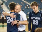 Skyview's Jace Chatman receives a hug from coach Matt Gruhler in a 4A State consolation game Friday at the Tacoma Dome. Skyview lost 75-55 to Olympia to end its season.