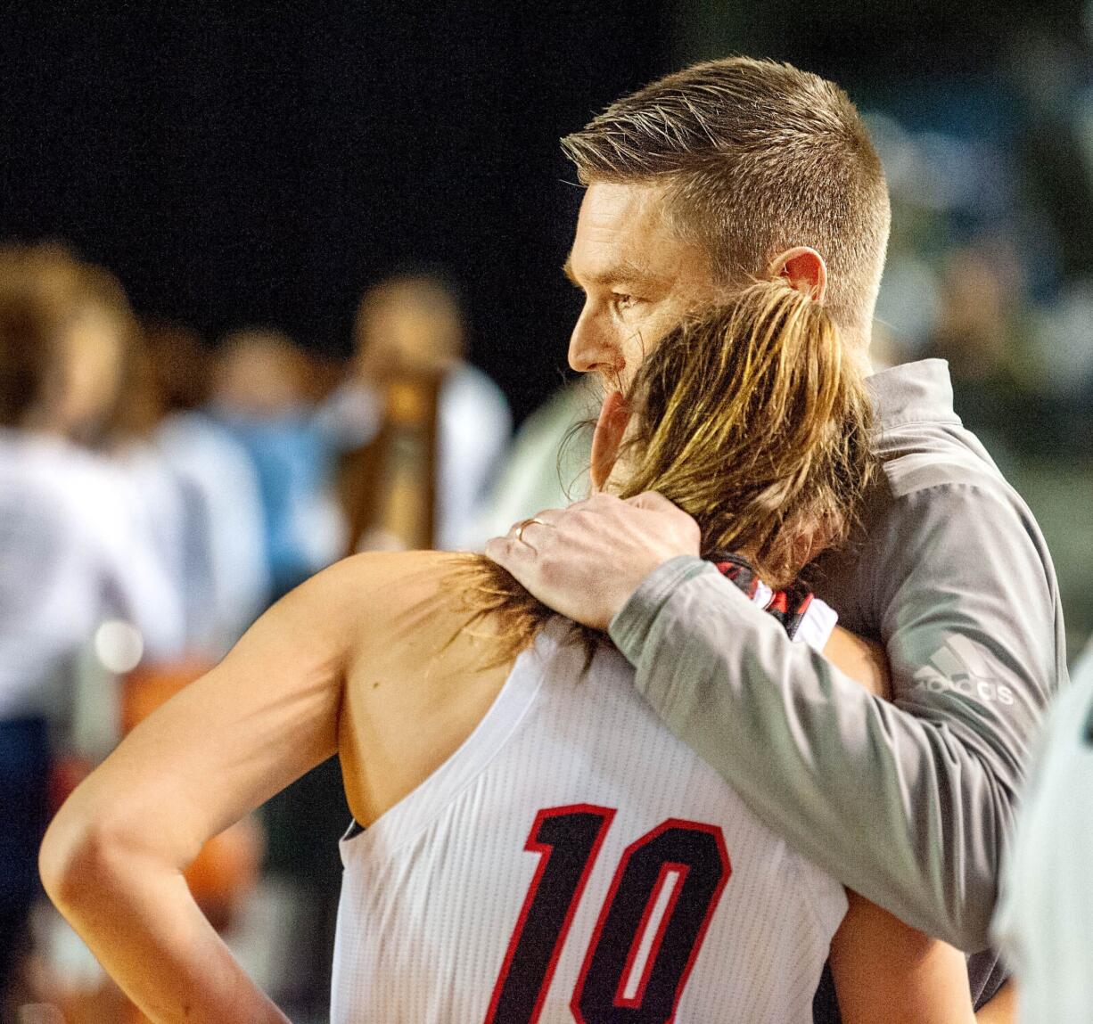 Union coach Gary Mills comforts Lolo Weatherspoon after the Titans' 47-45 defeat in a 4A State third-place game Saturday at the Tacoma Dome.