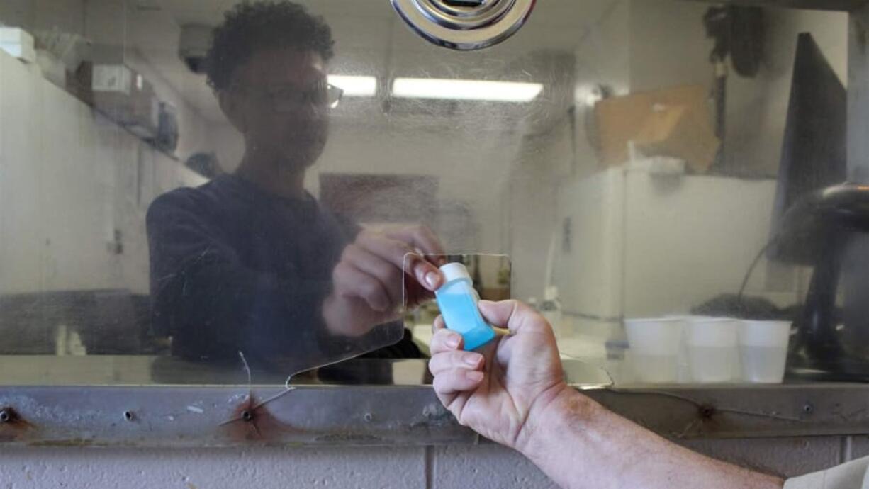 Nurse John Sepulveda demonstrates how he hands inmates their daily doses of methadone at a Rhode Island Department of Corrections prison in Cranston. Nationwide, more prisons and jails are starting to offer inmates methadone and buprenorphine for the treatment of opioid addiction.