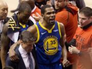 FILE - In this June 10, 2019, file photo, Golden State Warriors forward Kevin Durant (35) reacts as he leaves the court after sustaining an injury during first-half basketball action against the Toronto Raptors in Game 5 of the NBA Finals in Toronto. Durant is headed to the Brooklyn Nets, leaving the Warriors after three seasons. His decision was announced Sunday, June 30, 2019, at the start of the NBA free agency period on the Instagram page for The Boardroom, an online series looking at sports business produced by Durant and business partner Rich Kleiman.