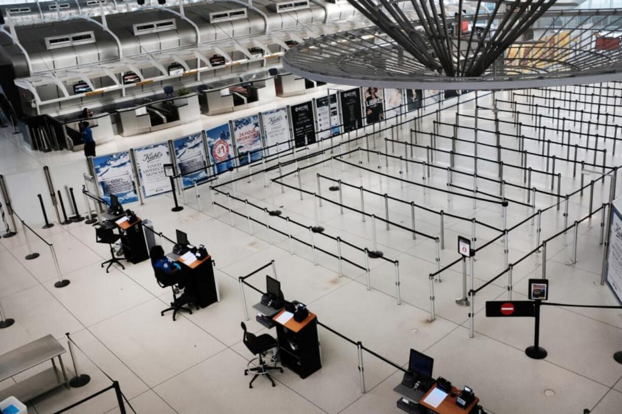 People walk through a sparse international departure terminal at John F. Kennedy Airport as concern over the coronavirus grows on March 7 in New York City, N.Y.