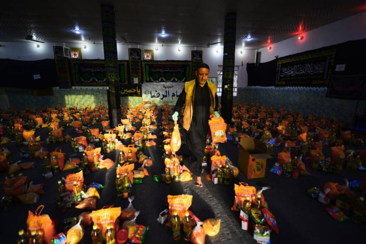 A man sorts donations for families in need in the central Iraqi holy city of Najaf on Wednesday, March 25, 2020 amid the COVID-19 coronavirus pandemic.