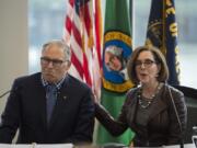 Washington Gov. Jay Inslee and Oregon Gov. Kate Brown talk to reporters before signing a memorandum of intent to replace the Interstate 5 Bridge during an event in November at the Murdock Charitable Trust in Vancouver. The governors have taken on bigger responsibilities during the coronavirus pandemic, which has lacked an efficient, uniform federal response.