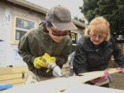 Tsering Wangden, left, and Sharon McConnell, right, volunteer on a construction site as part of Habitat for Humanity International Women Build Week 2020 on Saturday. About a dozen women worked on the site, preparing it for future resident Ting Mangshang and his family.