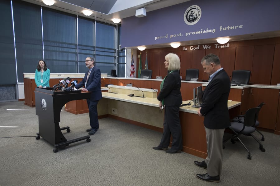 Clark County Public Health Officer Dr. Alan Melnick, at lectern, speaks about two local COVID-19 deaths at a Tuesday morning press conference at the Public Service Center in downtown Vancouver. Joining him are Marissa Armstrong, from left, public information officer for Clark County Public Health, County Council Chair Eileen Quiring and Clark County Councilor Gary Medvigy.