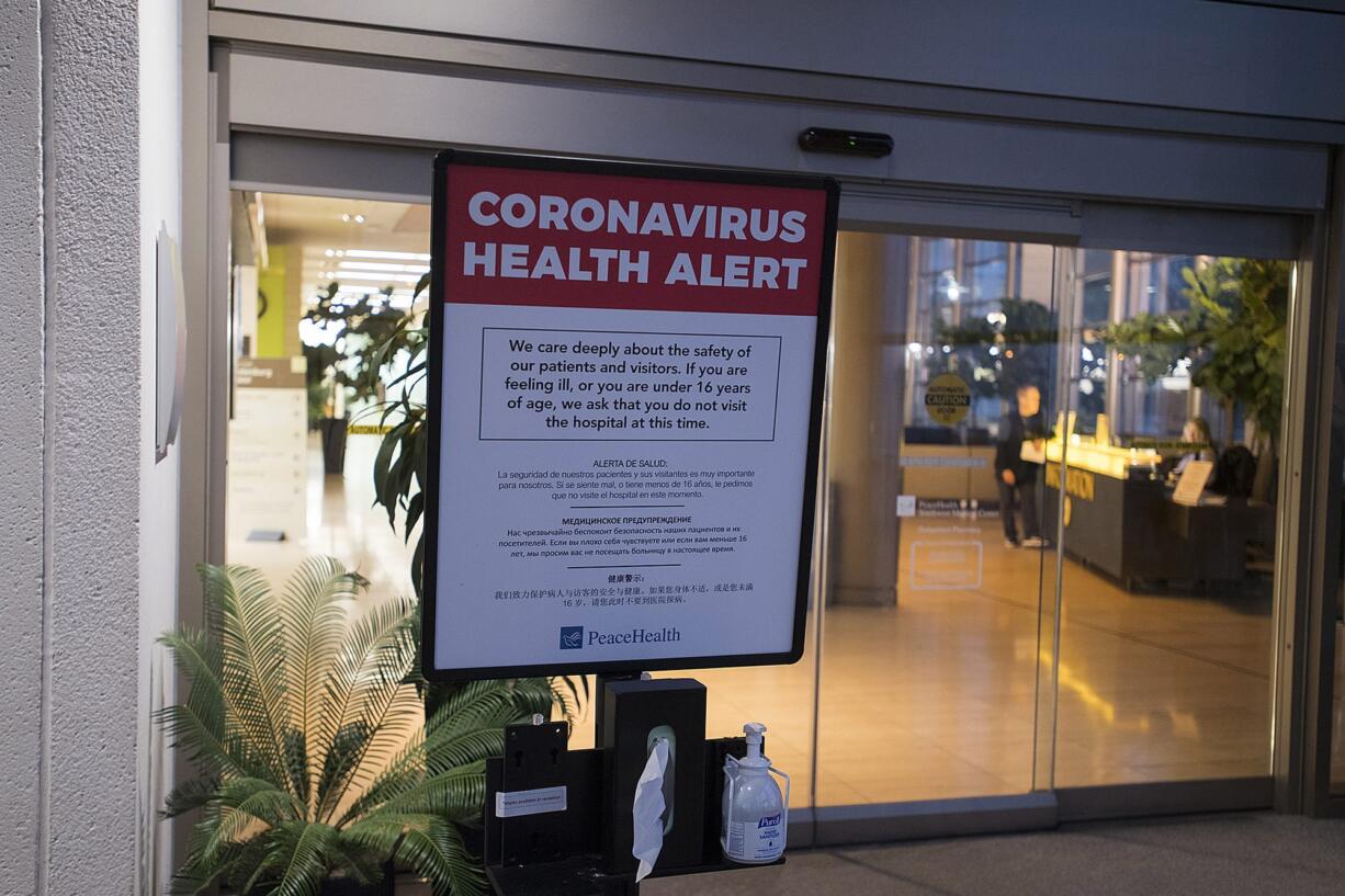 A coronavirus health alert sign is posted at one of the entrances to the Firstenburg Tower at PeaceHealth Southwest Medical Center on Monday morning, March 9, 2020.