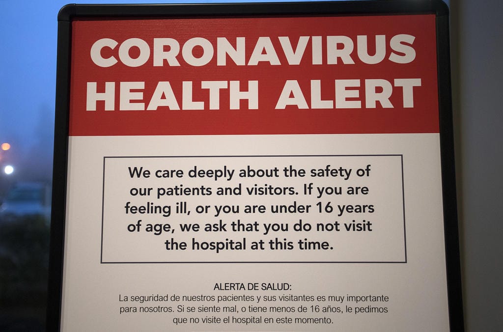 A coronavirus health alert sign is posted at one of the entrances to the Firstenburg Tower at PeaceHealth Southwest Medical Center on Monday morning, March 9, 2020. PeaceHealth has since gone to a no visitor policy.