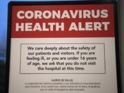 A coronavirus health alert sign is posted at one of the entrances to the Firstenburg Tower at PeaceHealth Southwest Medical Center on Monday morning, March 9, 2020. PeaceHealth has since gone to a no visitor policy.