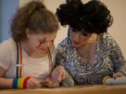 Rabbi Elizabeth Dunsker helps Lila Goldfarb, 11, find her place reading the Megillah. Third- and fourth-year Hebrew students took turns reading the text.