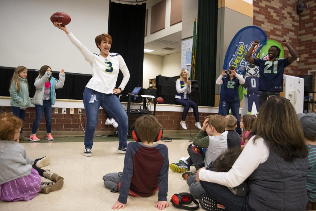 York Elementary School teacher Susanne Smith does her best version of a touchdown dance as Seahawks player Tre Flowers, right, cheers her on during his visit to York Elementary School on Monday, March 9, 2020. The Dairy Farmers of Washington and the Seattle Seahawks visited the school on Monday to celebrate their new cafeteria milk dispensers. The self-serve milk dispensers use washable cups will help reduce the schoolÕs environmental impact. York Elementary School is the first school to participate in this program. ÒYork Elementary set the example that five other schools in Clark County have followed,Ó said Michelle Sanow, Green Schools environmental outreach specialist.