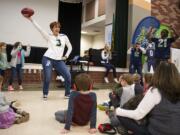 York Elementary School teacher Susanne Smith does her best version of a touchdown dance as Seahawks player Tre Flowers, right, cheers her on during his visit to York Elementary School on Monday, March 9, 2020. The Dairy Farmers of Washington and the Seattle Seahawks visited the school on Monday to celebrate their new cafeteria milk dispensers. The self-serve milk dispensers use washable cups will help reduce the schoolÕs environmental impact. York Elementary School is the first school to participate in this program. ÒYork Elementary set the example that five other schools in Clark County have followed,Ó said Michelle Sanow, Green Schools environmental outreach specialist.