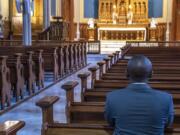 Javier KM prays in the mostly empty nave of The Proto-Cathedral of St. James the Greater in downtown Vancouver.