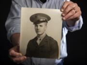 Jeff Osborne holds a photo of his father, Bill Osborne, taken around 1943. Marine Cpl. Bill Osborne trained for the battle of Iwo Jima at Parker Ranch in Hawaii.