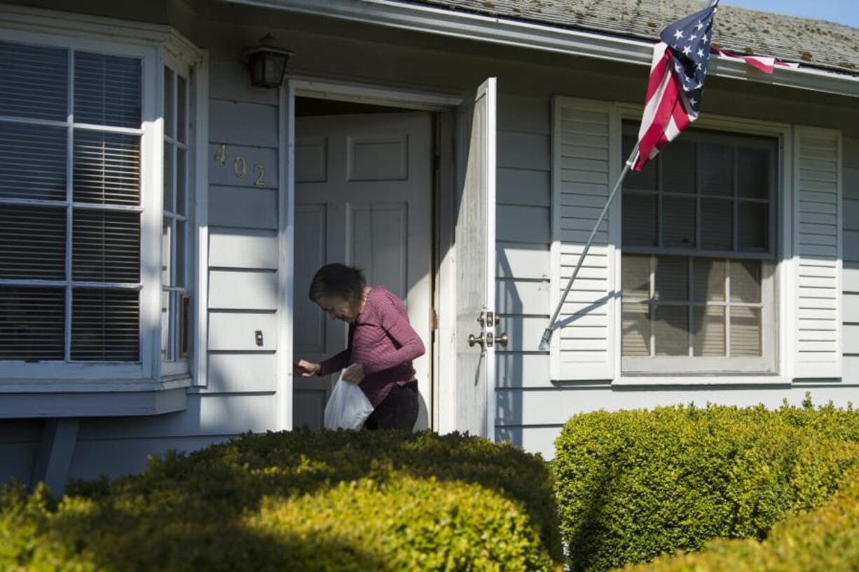 Fabiola Donnelly of Vancouver picks up her food from Meals on Wheels, which encourages people to check on their elderly neighbors. You can ring the bell and then step back to maintain a 6-foot distance.