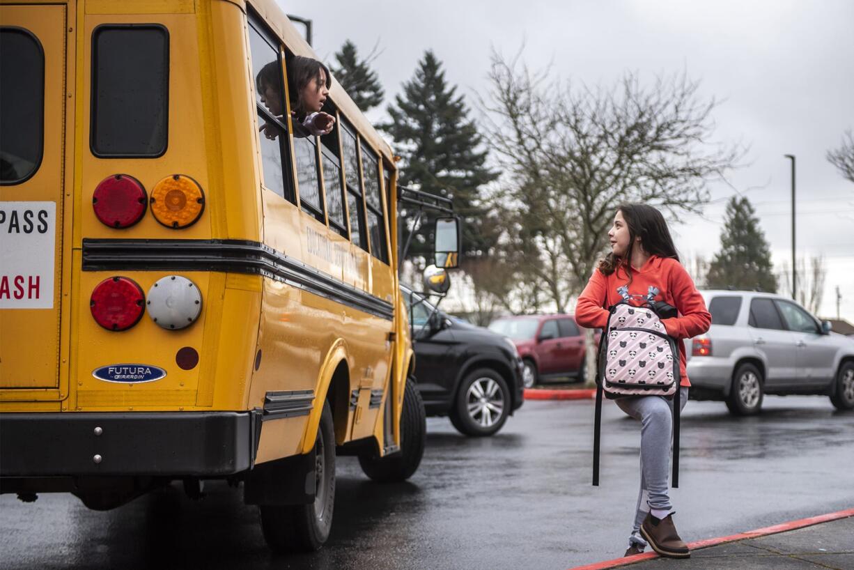 Trinity Breland, left, and Haydn Dorsey exchange phone numbers as Breland's bus pulls away from Covington Middle School so that the two can stay in touch on the final day of school for the 2019-2020 school year.