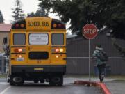 Owen Watt runs along side a school bus filled with fellow students as it pulls away from Covington Middle School on Friday afternoon, March 13, 2020.