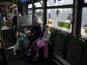 Linda Hilley of Vancouver rides The Vine on Wednesday with her grandchildren, Cali, 11, back left, Reno, 6, center, and Justice, 8, right. C-Tran reported a drop in ridership but has not reduced its routes. Hilley said she is watching her grandchildren because schools have been closed due to the novel coronavirus pandemic, and their parents are still working.