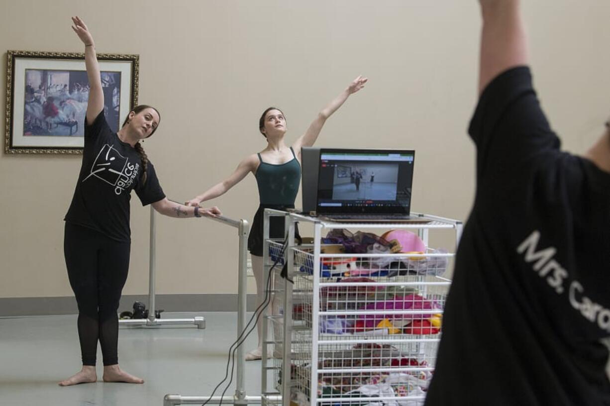 Carol Arroyo, a ballet teacher at Columbia Dance Center, left, and her daughter, Ava, 13, livestream a ballet class in an empty studio for adults unable to attend due to the COVID-19 quarantine on Wednesday morning. The school is closed through April 24 due to the virus, which has closed schools across the state.