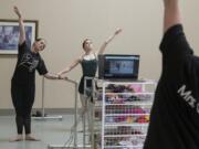Carol Arroyo, a ballet teacher at Columbia Dance Center, left, and her daughter, Ava, 13, livestream a ballet class in an empty studio for adults unable to attend due to the COVID-19 quarantine on Wednesday morning. The school is closed through April 24 due to the virus, which has closed schools across the state.