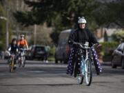 Vancouver Public Schools teacher Jennifer Patton leads a socially distanced ride through the Edgewood Park neighborhood in Vancouver on Monday. Patton has been biking through the neighborhood in a different costume each day for the past week. &quot;I use to teach kindergarten,&quot; she said.