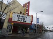 Vancouver resident Elizabeth Hay walks her bike past Kiggins Theatre on a nearly empty Main Street on Friday morning. Kiggins is currently closed but has partnered with an independent film streaming service.