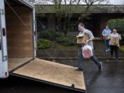 Jeff Paul, from left, Beth Paul and Corina Kwiatt-Dashiell of In It Together RN load a trailer to deliver toilet paper and cleaning supplies to local adult family homes. The Pauls are trying to help adult family home caregivers by finding toilet paper and other necessities for them.