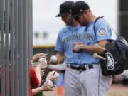 Seattle Mariners' Connor Lien, left, and Mitch Nay stop to sign autographs before a spring training baseball game against the Los Angeles Angels on Tuesday, March 10, 2020, in Peoria, Ariz.