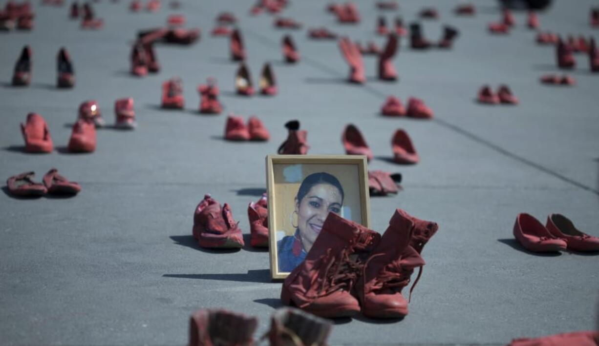 A portrait of Eugenia Machuca Campos, who was slain by her boyfriend, is surrounded by an installation of red women&#039;s shoes in a protest against gender violence Jan. 11  in Mexico City.