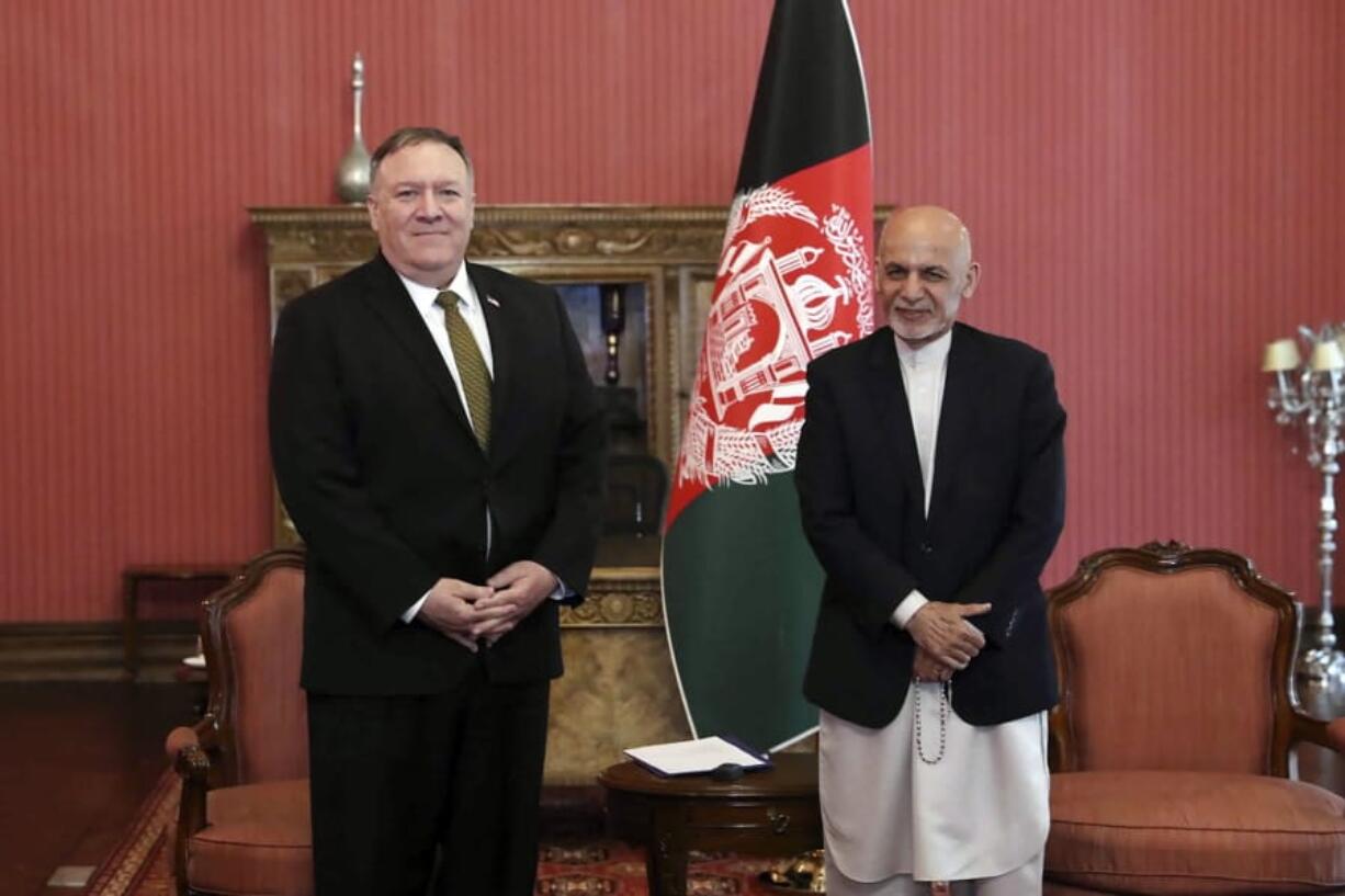 U.S. Secretary of State Mike Pompeo, left, stands with Afghan President Ashraf Ghani, at the Presidential Palace in Kabul, Afghanistan, Monday, March 23, 2020. Pompeo was in Kabul on an urgent visit Monday to try to move forward a U.S. peace deal signed last month with the Taliban, a trip that comes despite the coronavirus pandemic, at a time when world leaders and statesmen are curtailing official travel.