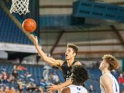 Battle Ground's Kaden Perry lofts the ball off the backboard to himself for a dunk in a 4A State round-of-12 game Wednesday at the Tacoma Dome.