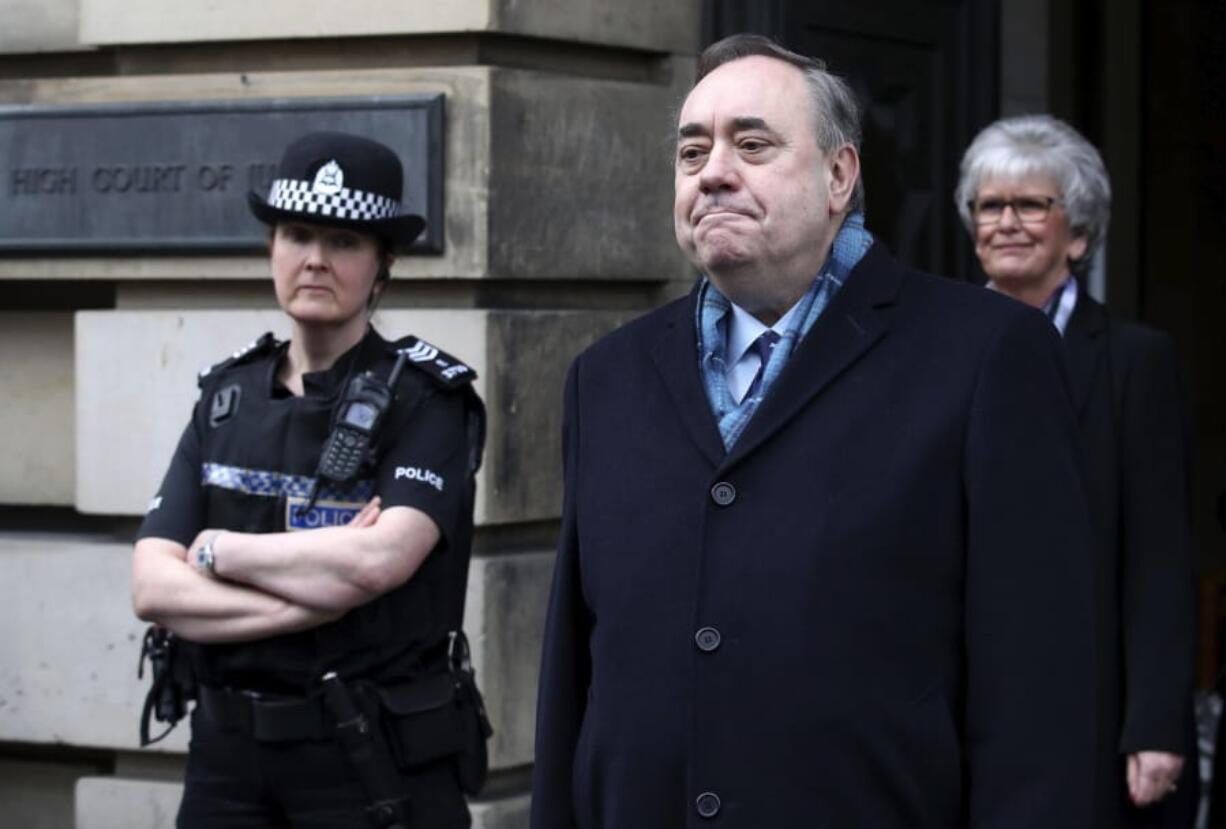 Alex Salmond foreground left, speaks to the media as he leaves the High Court after he was cleared of attempted rape and a series of sexual assaults, including one with intent to rape, against nine women, who were all either working for the Scottish Government or within the SNP at the time, in Edinburgh, Monday March 23, 2020.