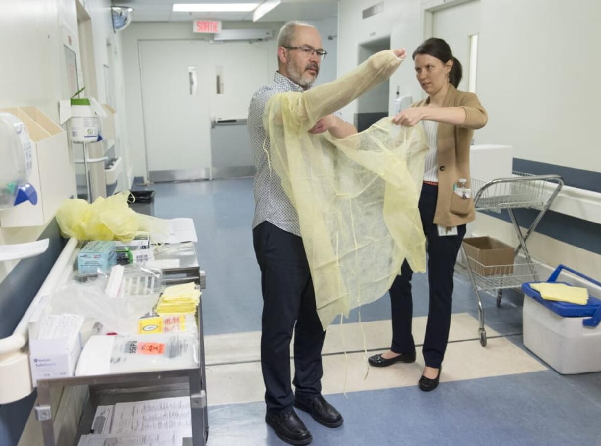 Health workers demonstrate how to put on protective clothing during a tour of a COVID-19 evaluation clinic in Montreal, Quebec, Canada on Tuesday, March 10, 2020.