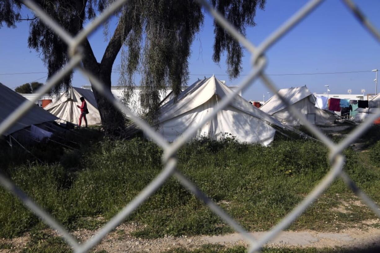 A migrant walks by the tents inside a refugee camp in Kokkinotrimithia outside of Nicosia, Cyprus, Tuesday, March 3, 2020. The government of ethnically divided Cyprus is ramping up measures to stem migrant inflows amid fears of a surge of new arrivals following Turkey&#039;s decision to open its borders to those seeking to enter Europe illegally.