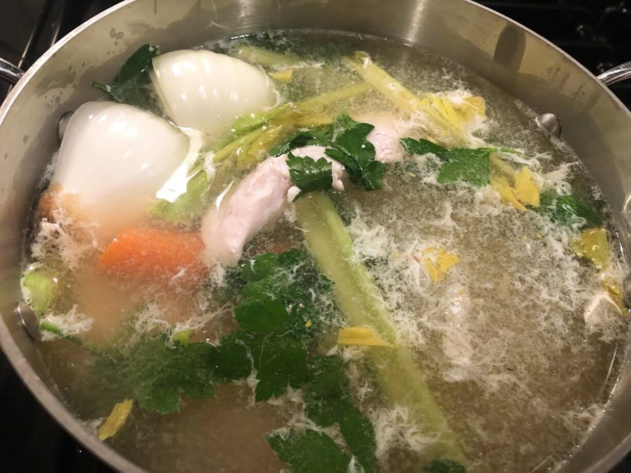 Boneless chicken poaching in a broth.