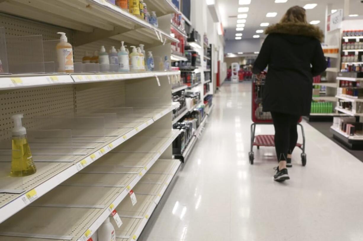 FILE - In this March 3, 2020 file photo, shelves that held hand sanitizer and hand soap are mostly empty at a Target in Jersey City, N.J.    People who may have been exposed to the new coronavirus or who get sick with COVID-19 may be advised to stay home for as long as 14 days to keep from spreading it to others, according to the Centers for Disease Control. That&#039;s led many people to wonder if they could manage for two weeks at home without a run to the grocery store.