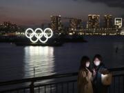 Two women take a selfie with the Olympic rings in the background in the Odaiba section of Tokyo, Thursday, March 12, 2020.  Doping testers around the sporting world are trying to avoid infecting themselves or athletes during the global virus outbreak, and that&#039;s not easy when collecting samples means getting very close to sports stars. (AP Photo/Jae C.