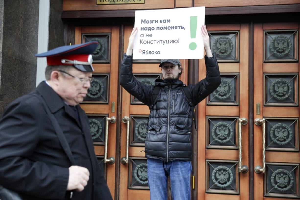 A member of the liberal Yabloko Party holds a poster reading: &quot;You need to change the brain, not the constitution!&quot; as he stages a one-man picket at the State Duma, the Lower House of the Russian Parliament in Moscow, Russia, Wednesday, March 11, 2020. The Russian parliament has approved a sweeping constitutional reform that will allow President Vladimir Putin to stay in power for another 12 years after his current term ends in 2024. Wednesday&#039;s vote was the third and final reading.