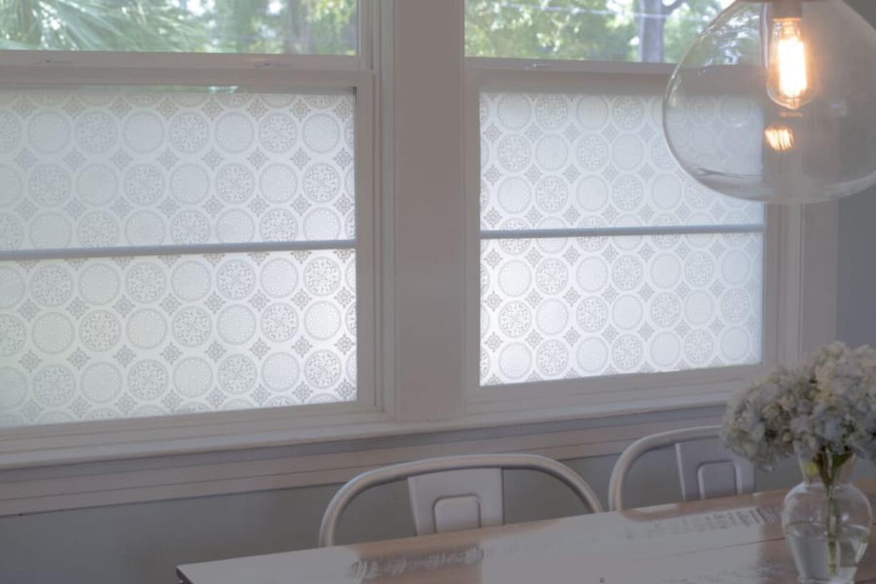 This photo shows StickPretty Gothica window film which shields street views from this family kitchen table while still allowing tree-filled sight lines.