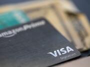 FILE This Aug. 11, 2019 file photo shows a Visa logo on a credit card in New Orleans.  A recent NerdWallet survey found that about a third of Americans plan to travel for spring break but only a third plan to use a credit card for some or all of these costs. That means plenty of spring breakers are missing out on points they could earn charging those expenses to a travel credit card. In addition to earning points, using a travel credit card can provide valuable trip protections and perks.